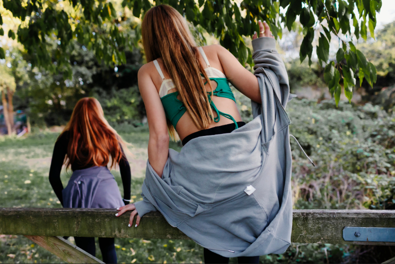 young ladies climbing a gate