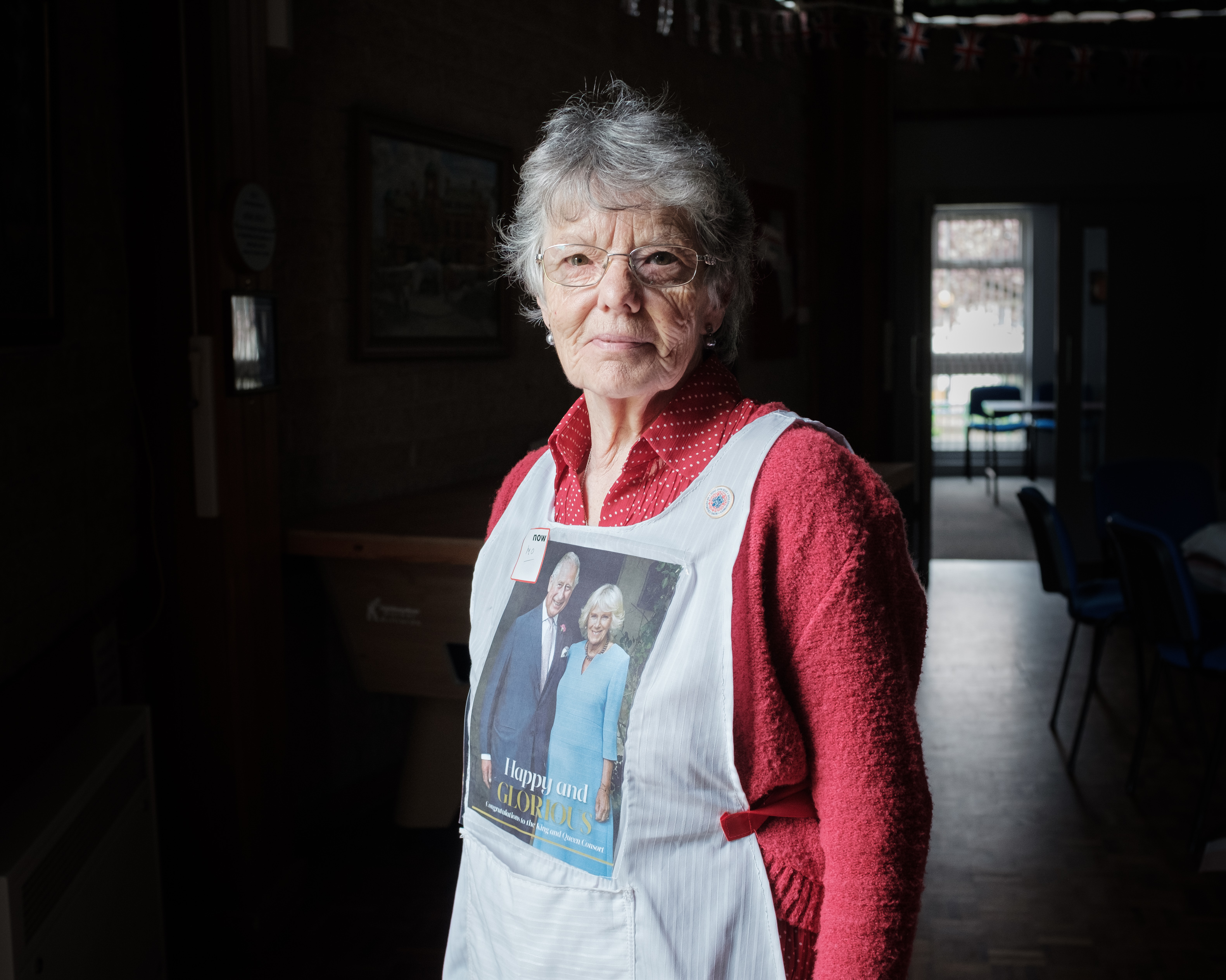 Elderly woman in red top and royal apron