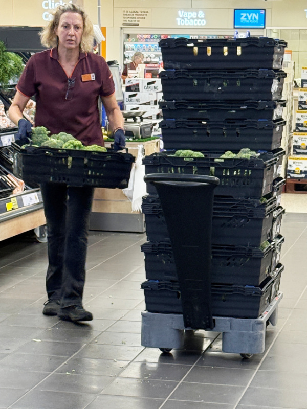 woman carrying tray of broccoli