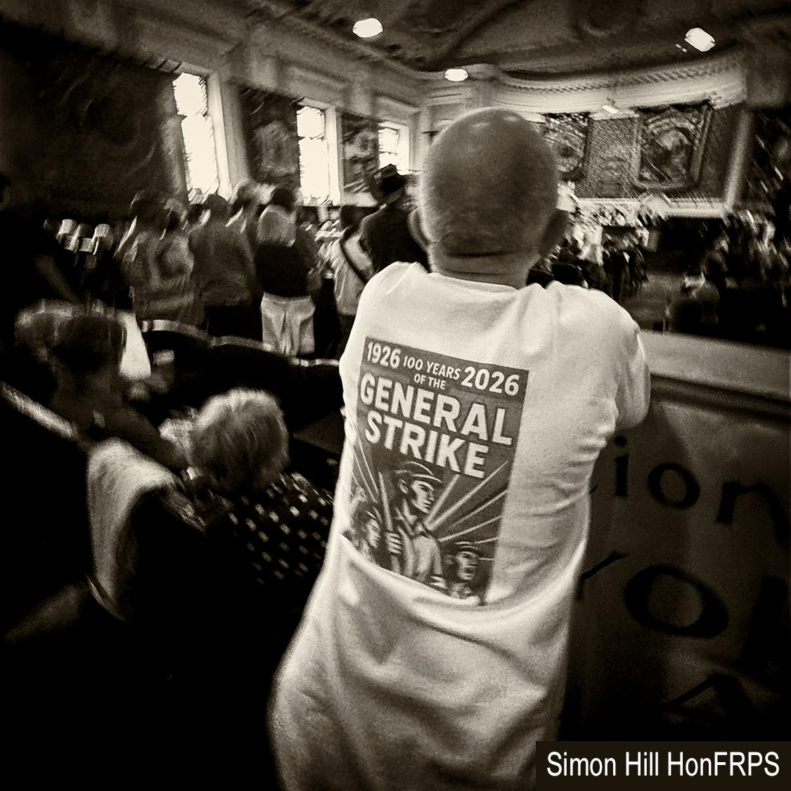Back view of a man wearing a t-shirt commemorating the 100th anniversary of the general strike in 1926.