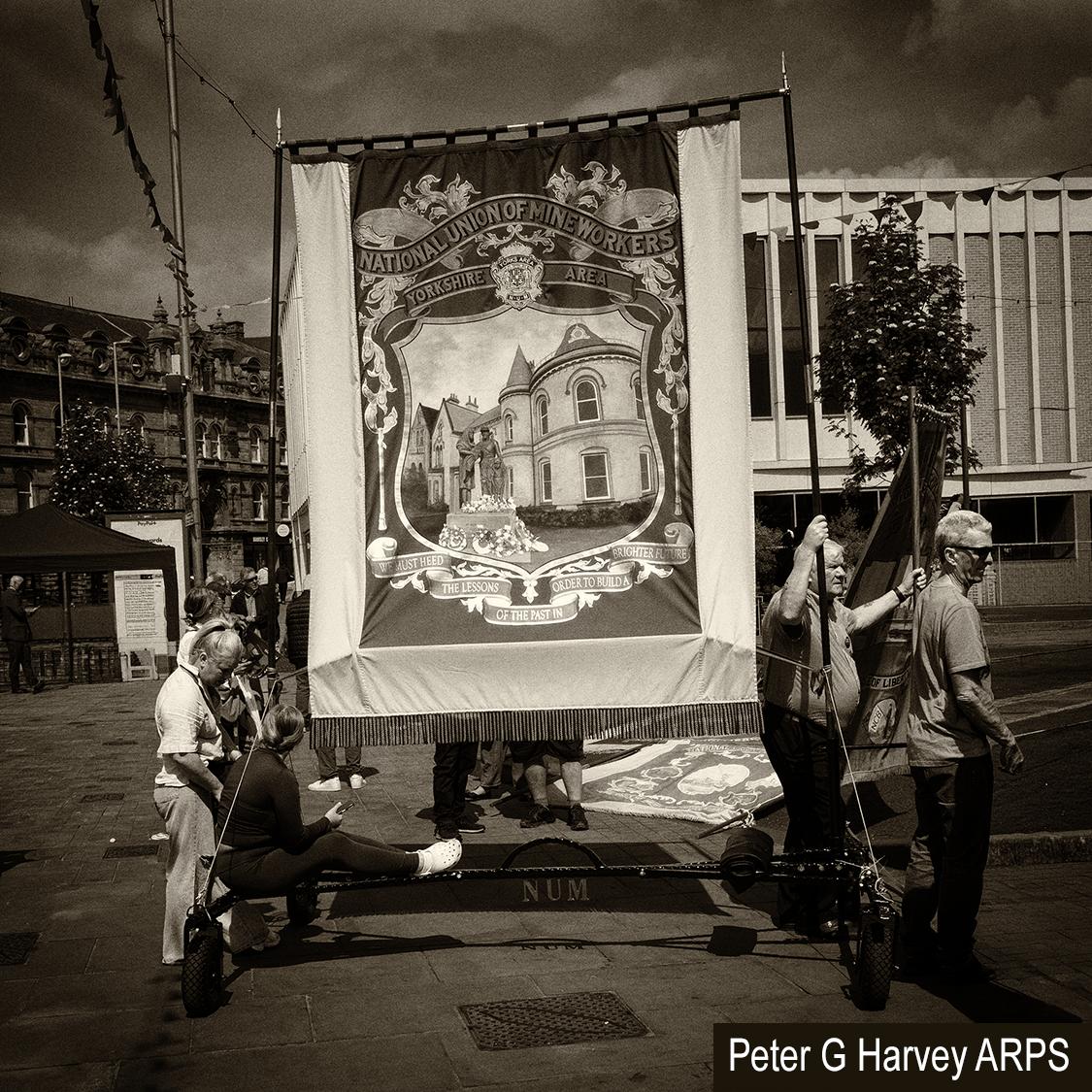 Men pulling a cart carrying a union banner