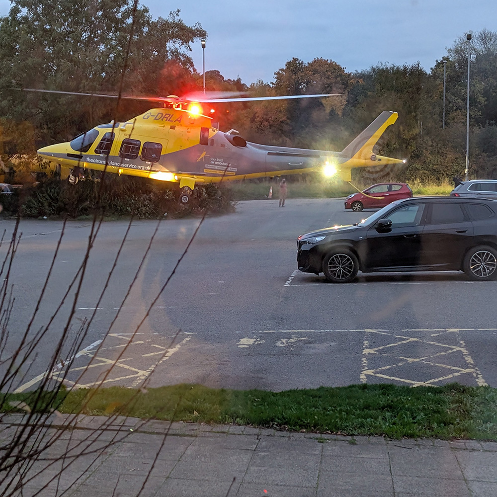 Air Ambulance Taking Off From Hotel Car Park by Sue Hutton