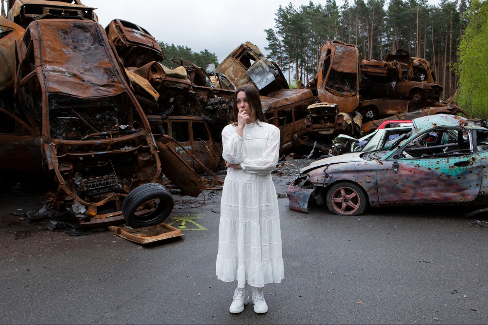 Woman in white dress in a junk yard